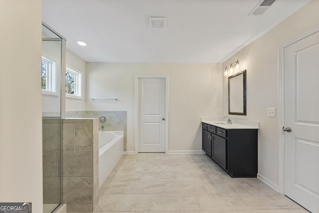 bathroom featuring vanity and tiled tub