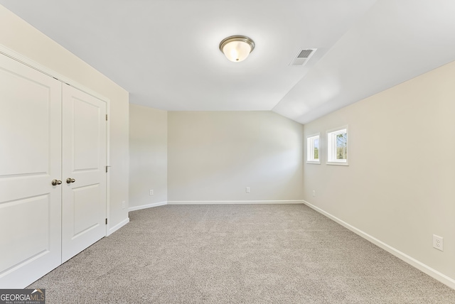 empty room with lofted ceiling and carpet flooring