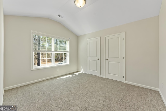 unfurnished bedroom with carpet and lofted ceiling