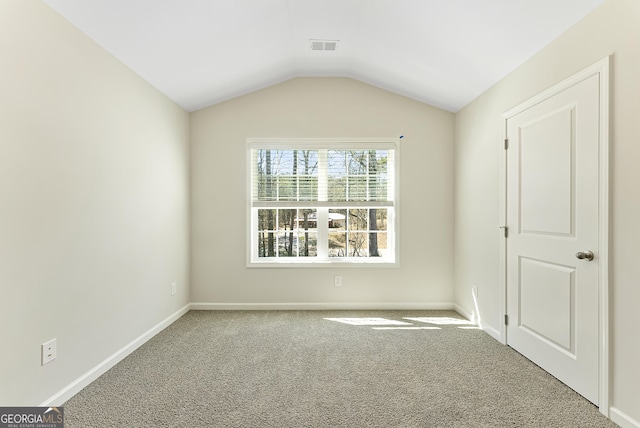 unfurnished room with vaulted ceiling and carpet flooring