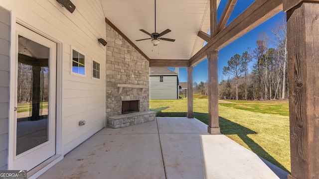 view of patio with ceiling fan and an outdoor stone fireplace