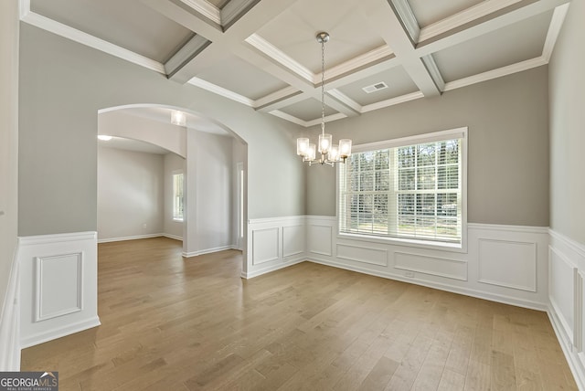 unfurnished dining area featuring light wood-type flooring, a wealth of natural light, and beam ceiling