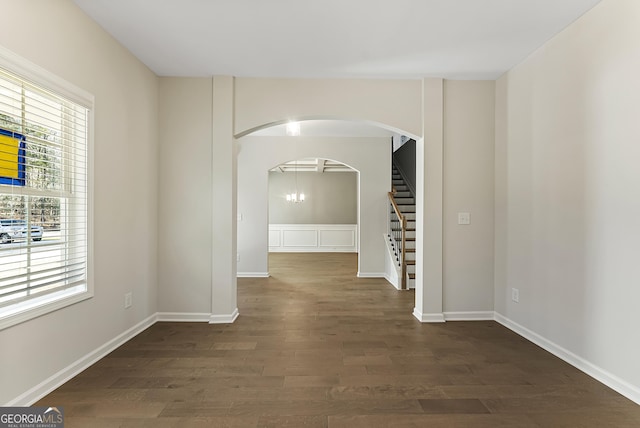 hallway featuring an inviting chandelier and dark wood-type flooring