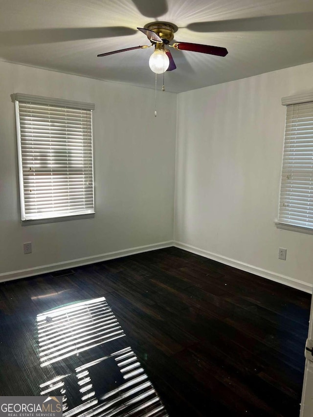 unfurnished room with ceiling fan and dark wood-type flooring