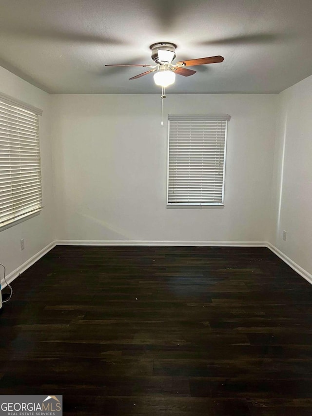 spare room with ceiling fan and dark hardwood / wood-style floors