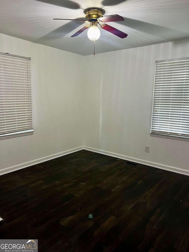 unfurnished room featuring ceiling fan and dark wood-type flooring