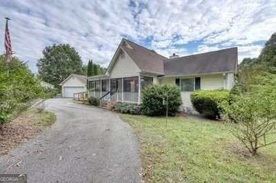 view of front of house featuring a front lawn, a sunroom, and a garage