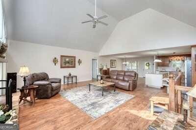 living room featuring wood-type flooring, high vaulted ceiling, and ceiling fan