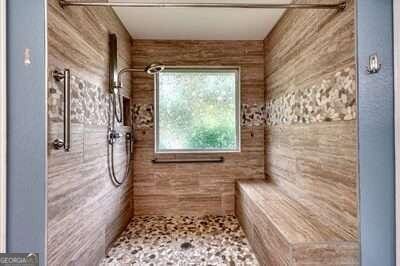 bathroom featuring a tile shower and wood walls