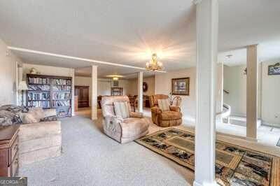 carpeted living room featuring a chandelier