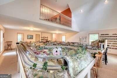 carpeted dining room with high vaulted ceiling