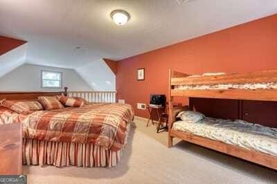 carpeted bedroom featuring lofted ceiling