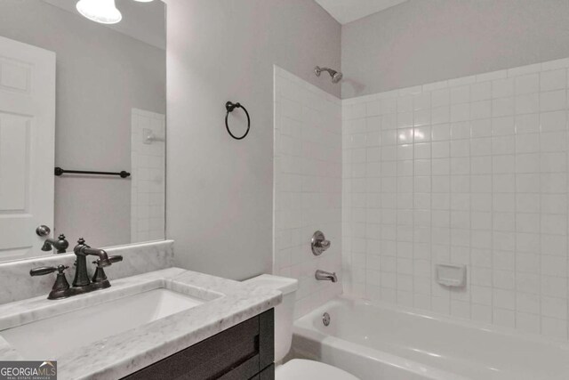 full bathroom with vanity, toilet, and tiled shower / bath combo