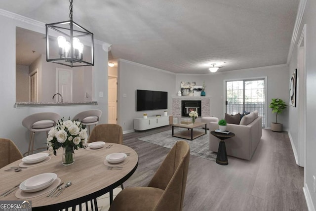 970 Sidney Marcus Blvd NE Unit 1204, Atlanta, GA 30324 - dining room with wood finished floors, ornamental molding, a chandelier, and a glass covered fireplace