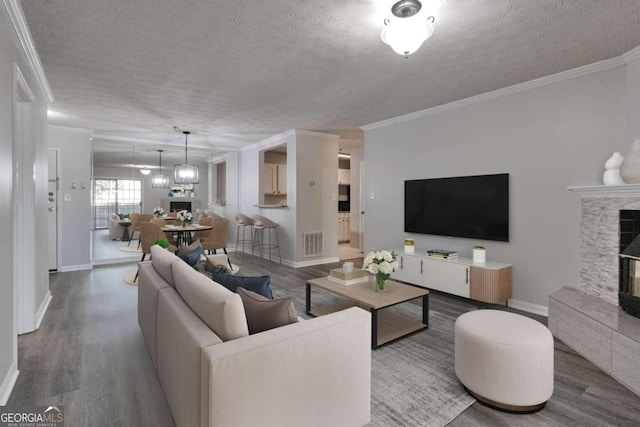 living room with ornamental molding, hardwood / wood-style floors, and a textured ceiling