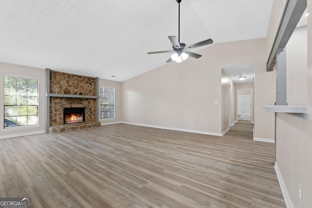 unfurnished living room featuring baseboards, ceiling fan, light wood-style flooring, and lofted ceiling