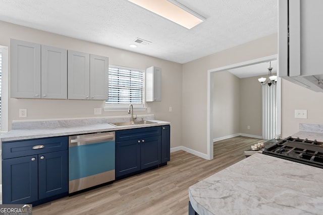 kitchen with blue cabinets, hanging light fixtures, sink, light hardwood / wood-style flooring, and dishwasher