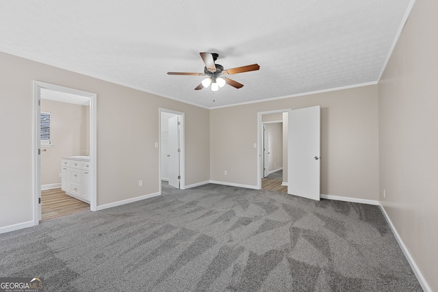 unfurnished bedroom featuring ensuite bathroom, ceiling fan, crown molding, light colored carpet, and a textured ceiling