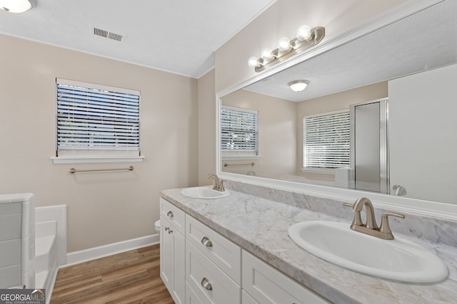 bathroom with a textured ceiling, hardwood / wood-style flooring, vanity, and shower with separate bathtub