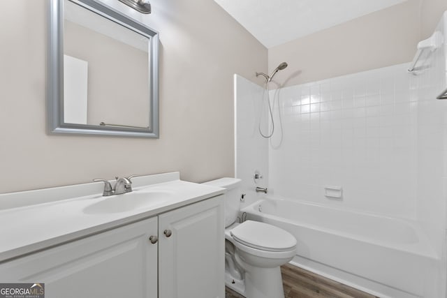 bathroom featuring vanity, washtub / shower combination, toilet, and wood finished floors