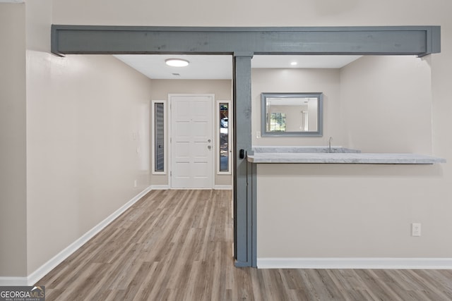 entryway with baseboards and wood finished floors