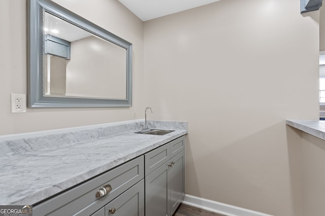 bathroom with vanity, baseboards, and wood finished floors
