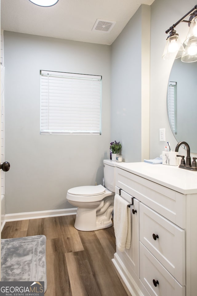 bathroom featuring vanity, toilet, and hardwood / wood-style flooring