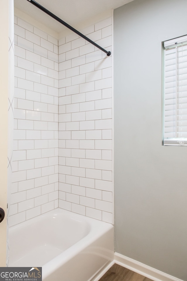 bathroom with hardwood / wood-style floors and tiled shower / bath combo