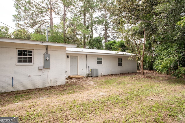 back of property featuring a yard and cooling unit