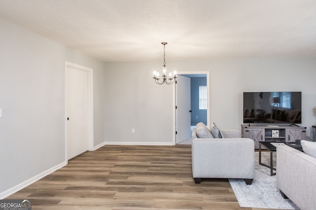 living room with hardwood / wood-style floors, a chandelier, and a textured ceiling