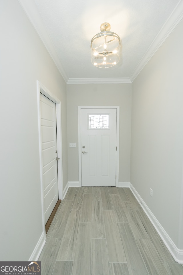 foyer featuring an inviting chandelier, light hardwood / wood-style floors, and ornamental molding