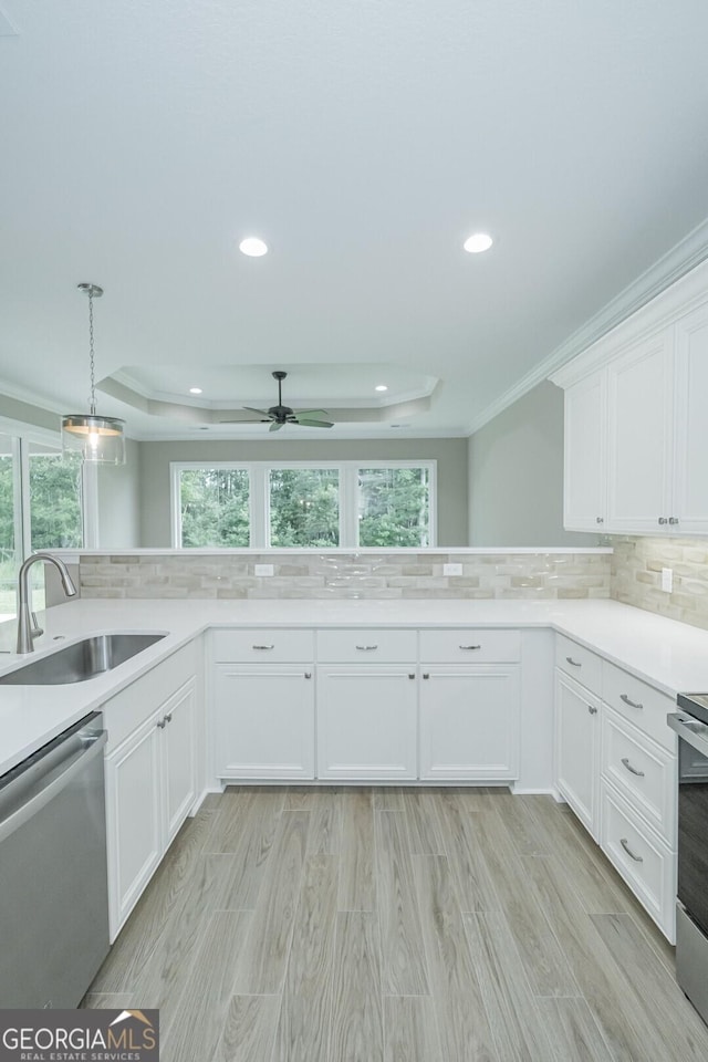 245 Ryan Nicholas Dr, Kingsland, GA 31548 - kitchen with appliances with stainless steel finishes, a sink, a raised ceiling, decorative backsplash, and ornamental molding