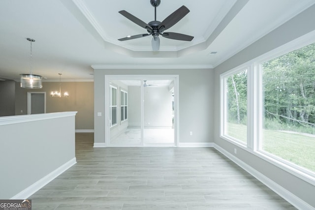 245 Ryan Nicholas Dr, Kingsland, GA 31548 - empty room featuring visible vents, ornamental molding, a raised ceiling, light wood finished floors, and ceiling fan with notable chandelier