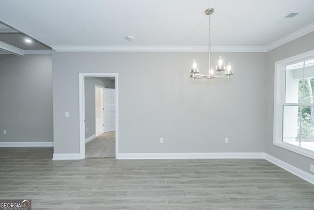 245 Ryan Nicholas Dr, Kingsland, GA 31548 - spare room with crown molding, baseboards, a chandelier, and light wood-type flooring