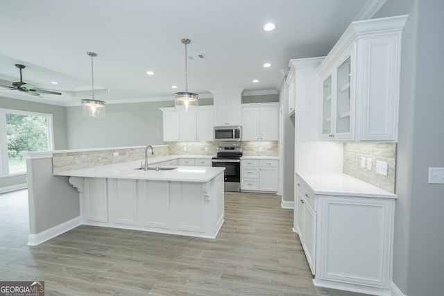 245 Ryan Nicholas Dr, Kingsland, GA 31548 - kitchen featuring decorative backsplash, appliances with stainless steel finishes, a sink, light countertops, and white cabinetry