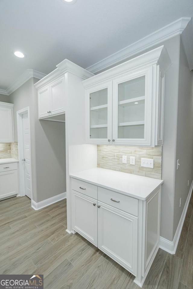 245 Ryan Nicholas Dr, Kingsland, GA 31548 - kitchen featuring crown molding, white cabinetry, baseboards, decorative backsplash, and glass insert cabinets