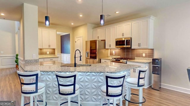 kitchen featuring hanging light fixtures, appliances with stainless steel finishes, sink, and white cabinetry