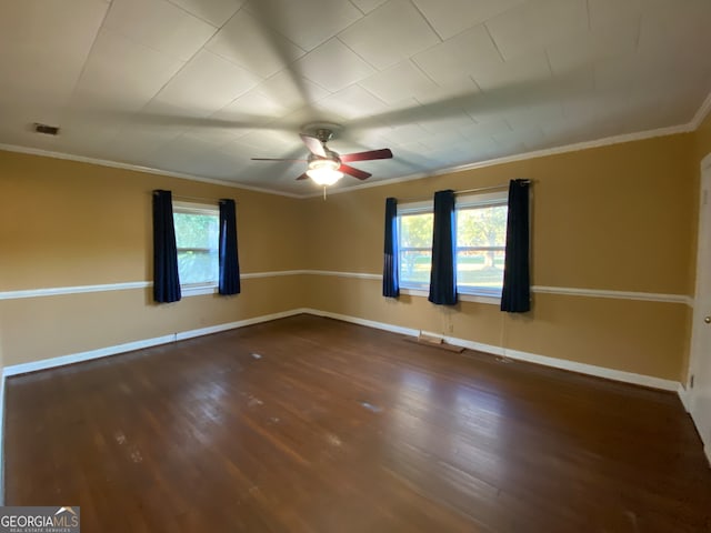 spare room with dark hardwood / wood-style floors, ornamental molding, and a healthy amount of sunlight