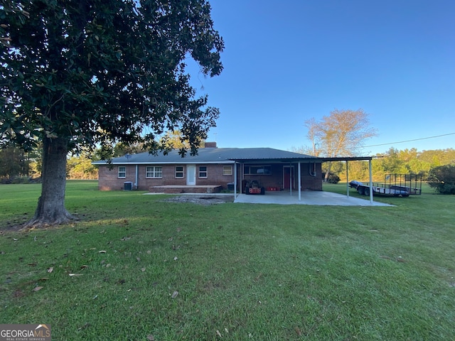 rear view of property with a yard and a patio area