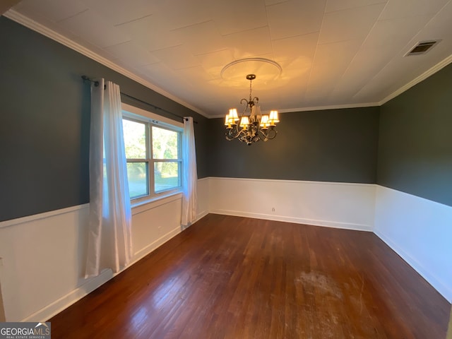 unfurnished dining area with dark hardwood / wood-style floors, crown molding, and an inviting chandelier