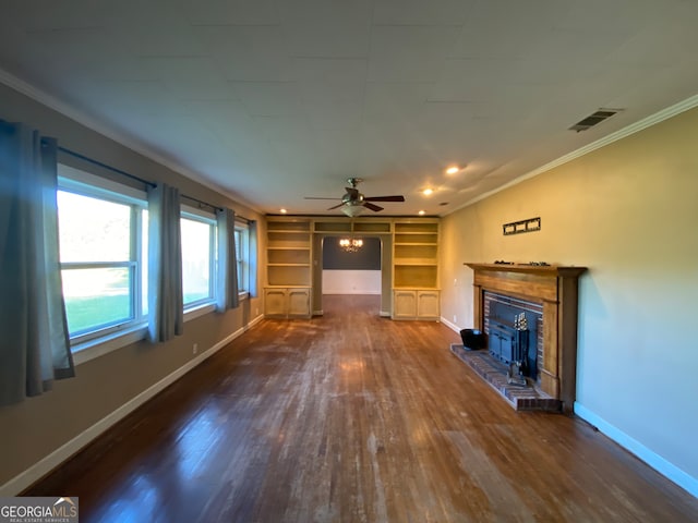 unfurnished living room with dark wood-type flooring, a brick fireplace, ornamental molding, and ceiling fan