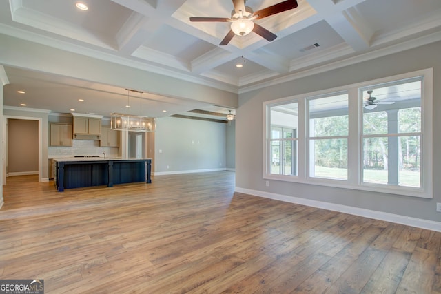 unfurnished living room with coffered ceiling, ceiling fan, crown molding, beam ceiling, and hardwood / wood-style floors