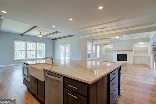 kitchen featuring a kitchen island with sink, ceiling fan, pendant lighting, dishwasher, and light hardwood / wood-style floors