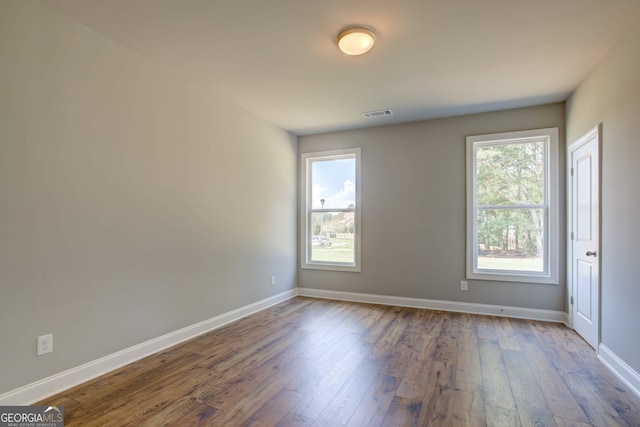 unfurnished room featuring hardwood / wood-style floors and a healthy amount of sunlight