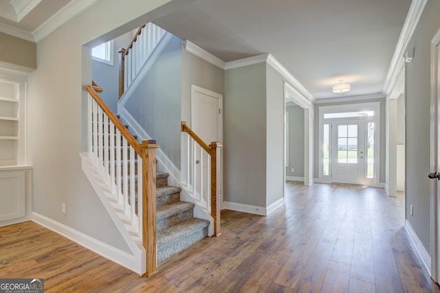 foyer entrance with wood-type flooring and ornamental molding