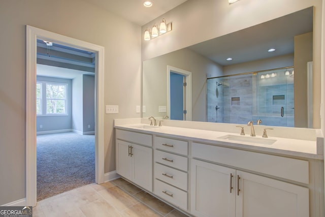 bathroom featuring tile patterned flooring, vanity, and a shower with shower door