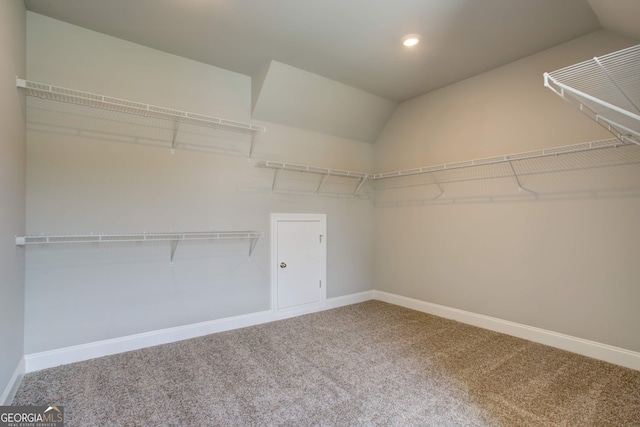 walk in closet featuring carpet flooring and vaulted ceiling