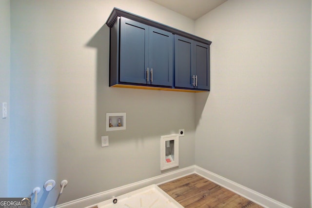 clothes washing area featuring cabinets, hookup for a gas dryer, hardwood / wood-style flooring, washer hookup, and hookup for an electric dryer