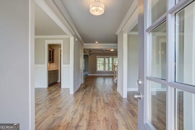 entrance foyer featuring crown molding and light hardwood / wood-style flooring