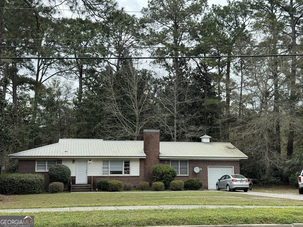 single story home featuring a garage and a front lawn